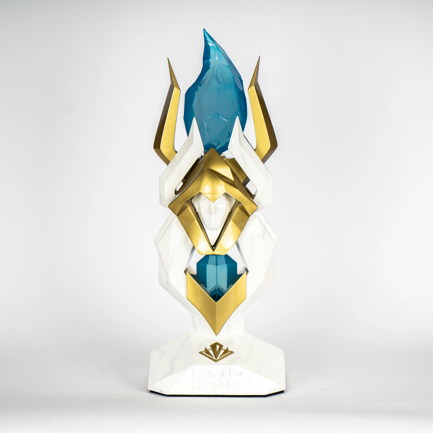 white and gold trophy stand with a blue gem on top
