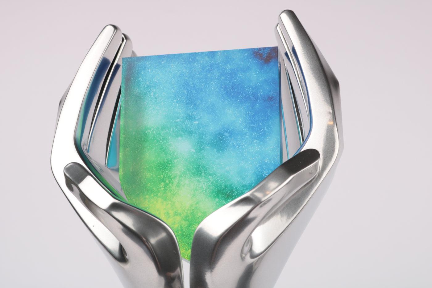 close-up of chrome silver abstract hands holding galaxy shield with stars