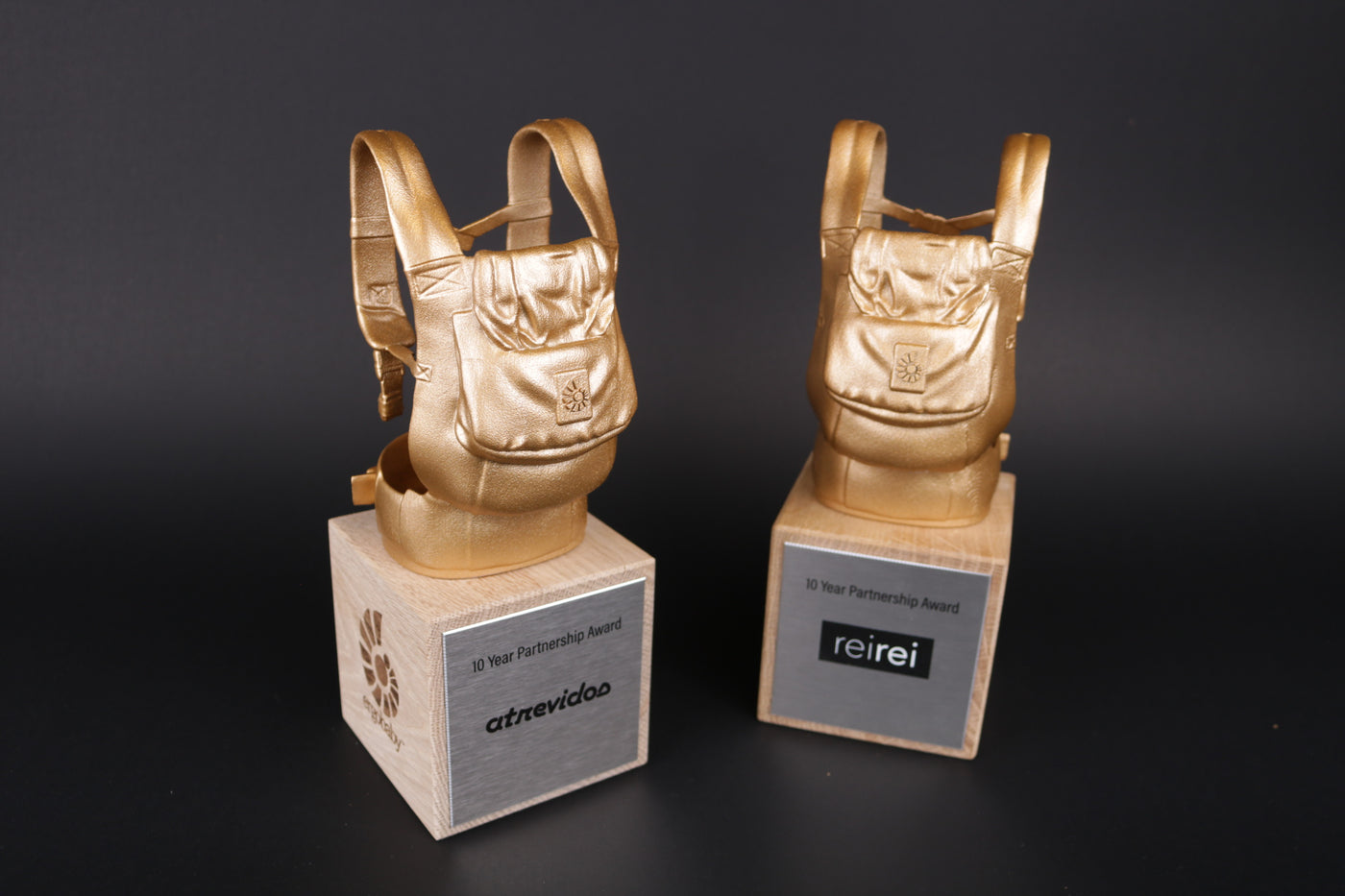 wooden trophy base with a golden 3d printed backpack on top