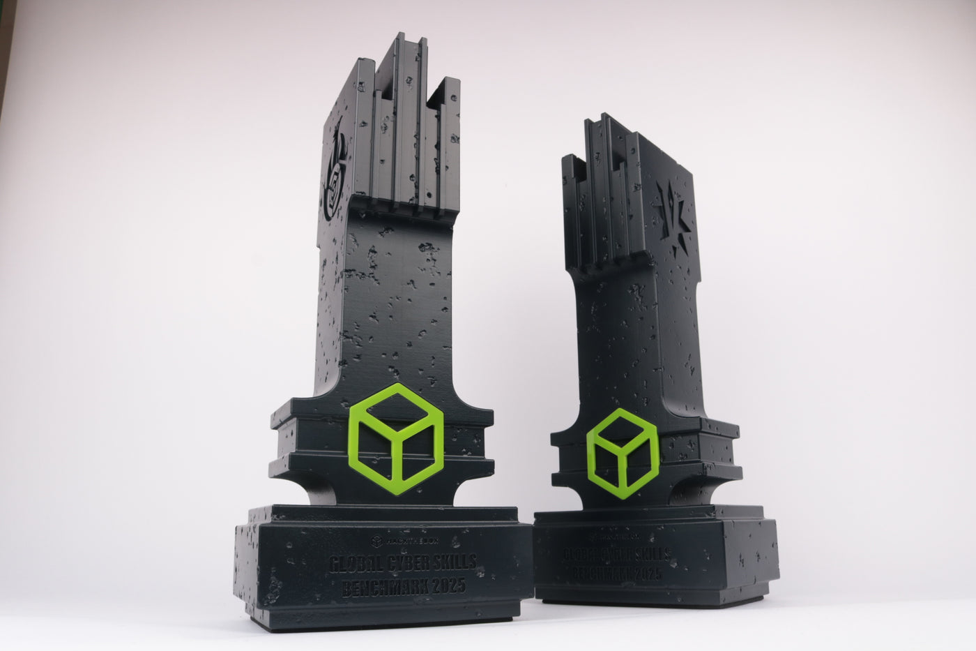Two brutalist trophies, 3d printed with cement look painted dark blue with neon green acrylic accents