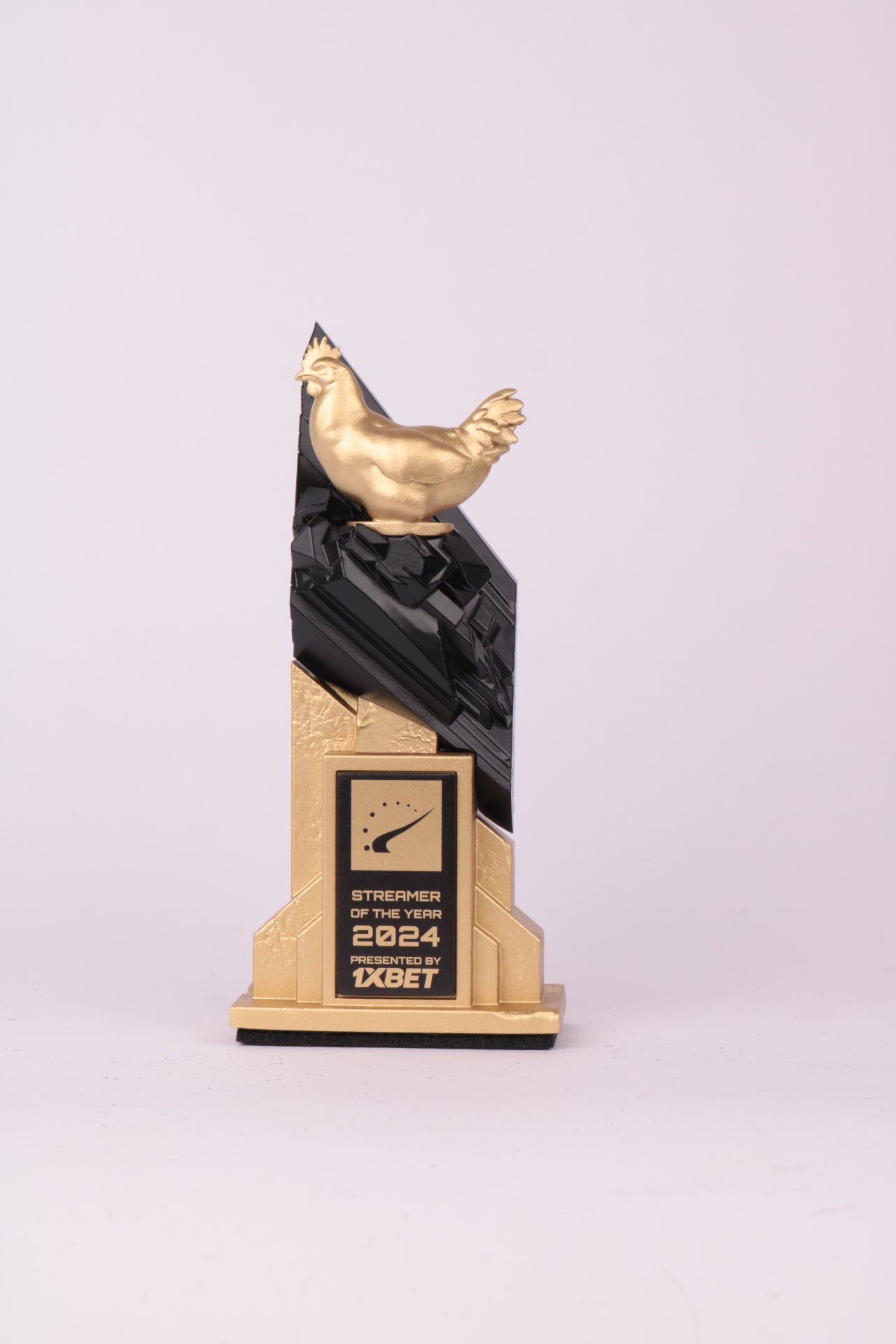 hltv counterstrike gaming trophy golden figurine in game character on black rocks and gold geometric base