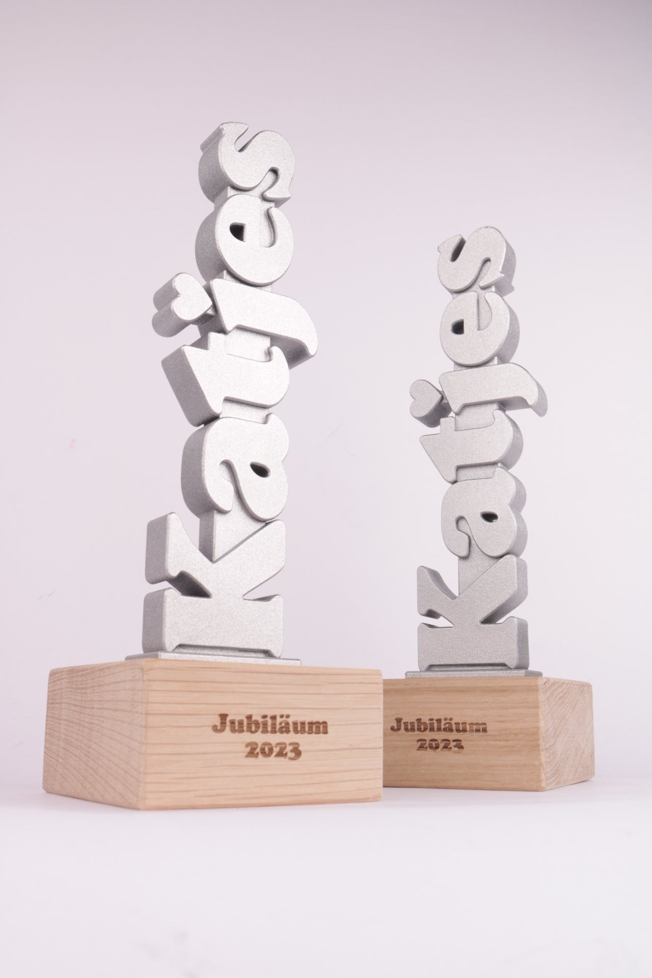 wooden trophy base with a silver looking 3d printed trophy on top