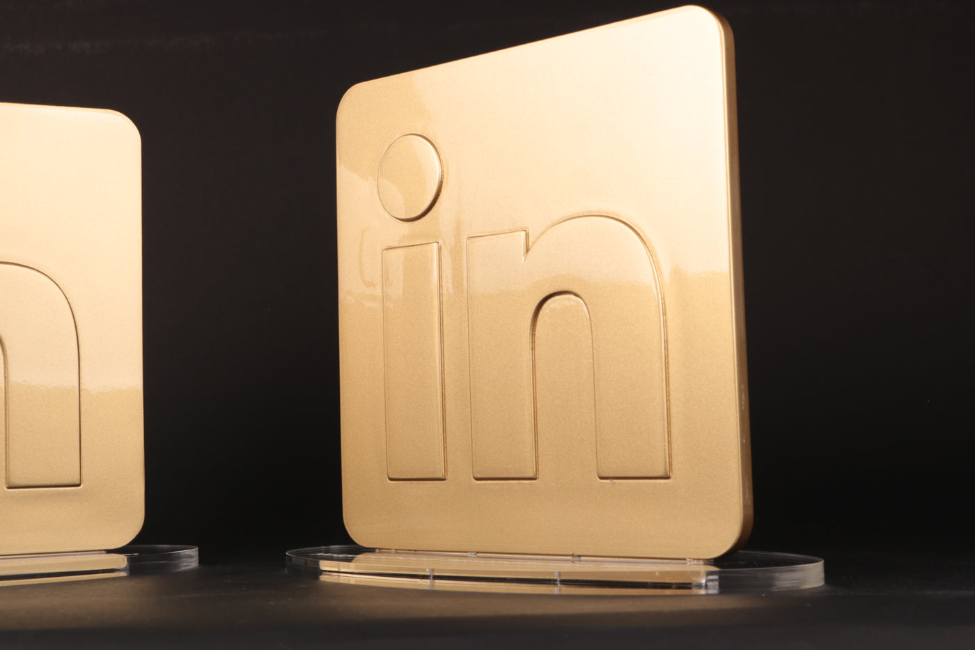 a gold plaque with the linkedin logo in 3d on an acrylic foot