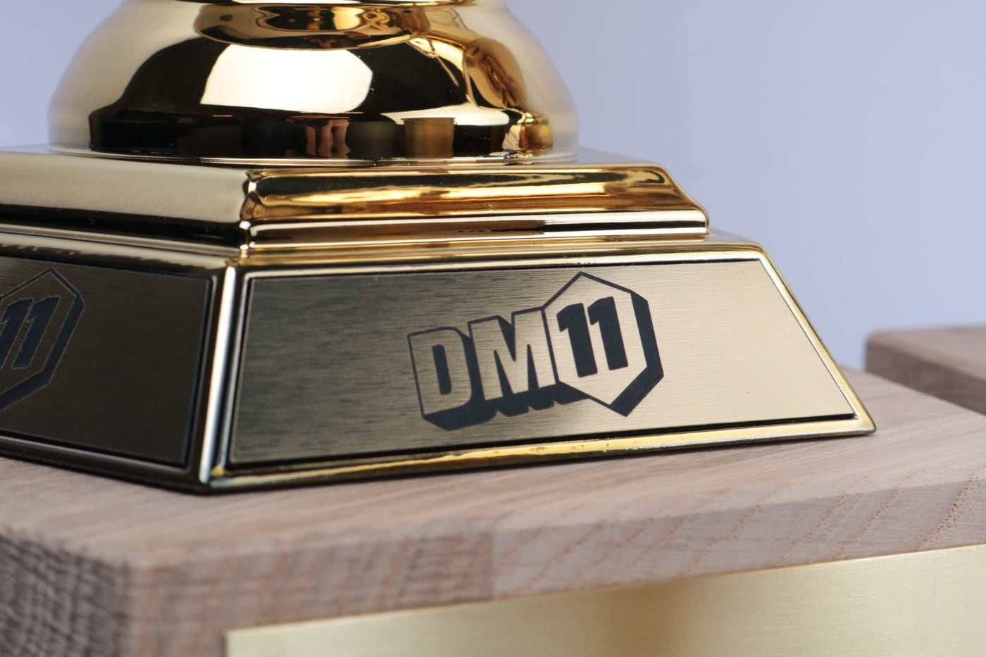 close-up of brushed metallic plaque on chrome gold trophy base with engraved logo