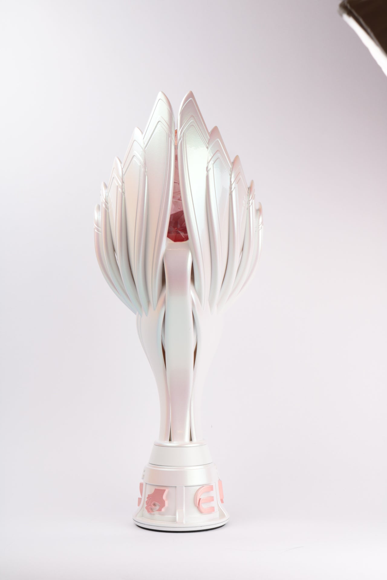 back view of pearlescent white throphy shaped like sea shells with soft pink details