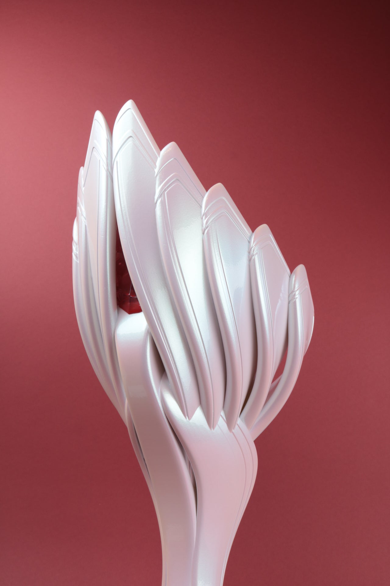 back view close-up of pearlescent white throphy shaped like sea shells with soft pink details on red backdrop