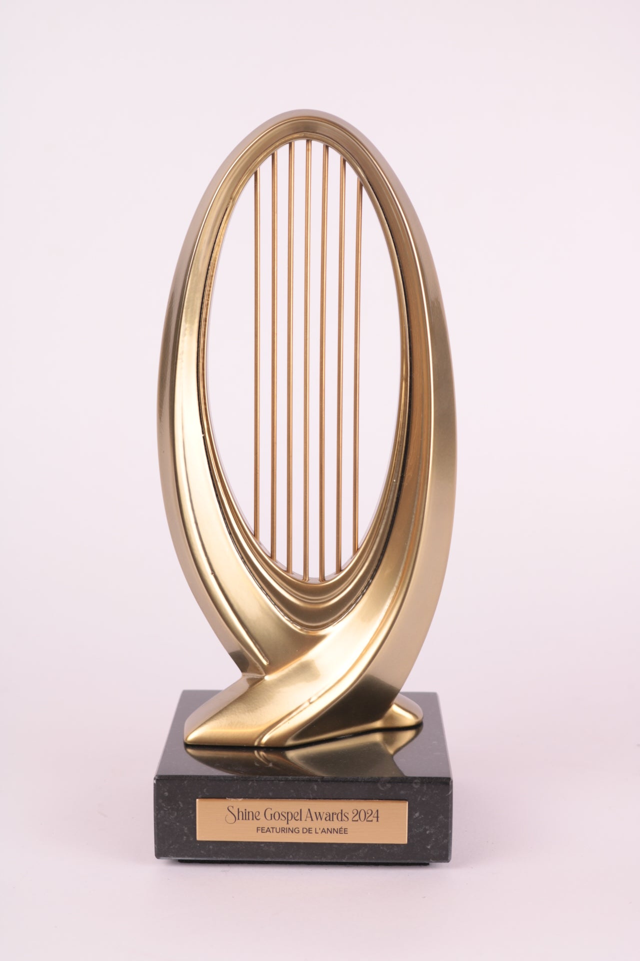 marbel trophy stand with a golden 3d printed harp on top