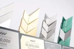 Close-up of Worthy Payments milestone awards with gold, silver and green chevron tops