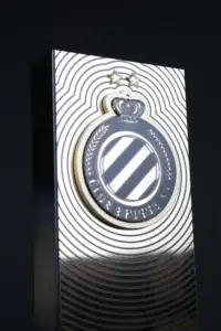 Close-up of a Club Brugge Player of the Month award with the club crest on a mirror silver panel