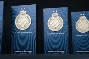 Row of navy Club Brugge Player of the Month awards with silver club crests