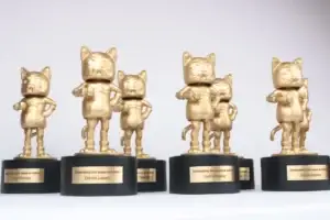 Gold cat figurine awards on black bases for the five year anniversary of AdHoc