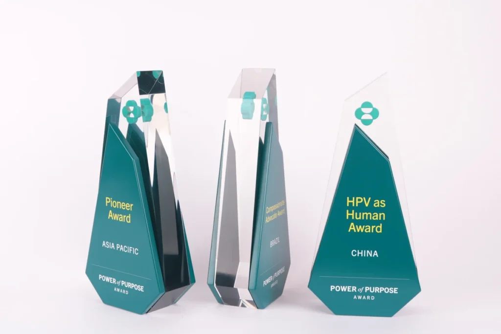 Three clear acrylic Power of Purpose awards with teal panels