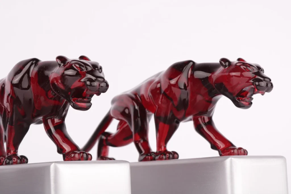 Red tinted transparent resin panther figurines on aluminium bases