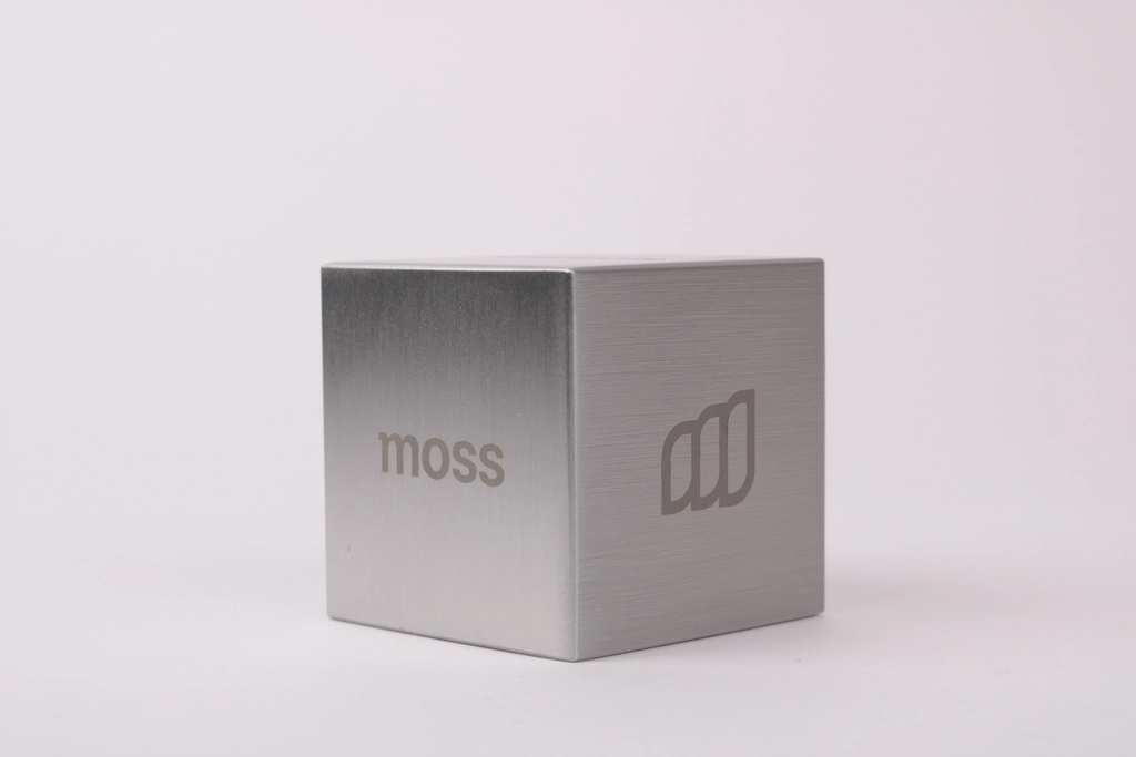 Brushed aluminium cube award for Moss with the engraved Moss wordmark on one face and the Moss logo on the other